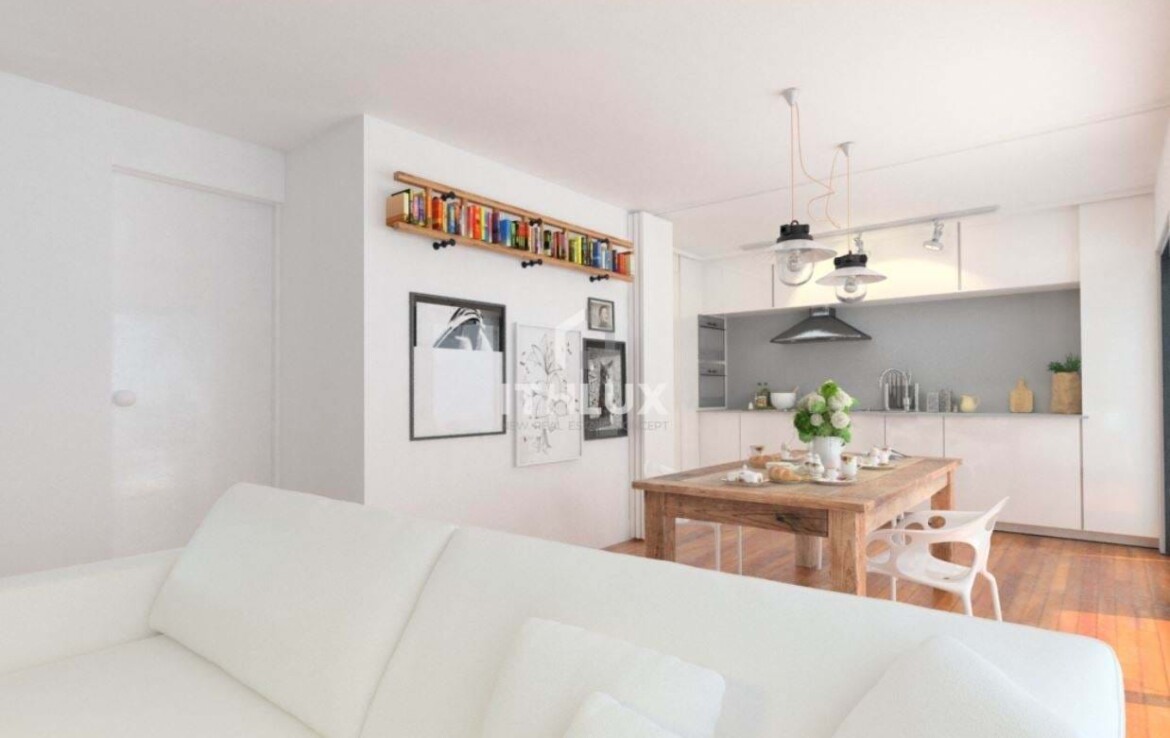 Modern nappali, fehér kanapéval, étkezőasztallal és könyvespolccal a falon.