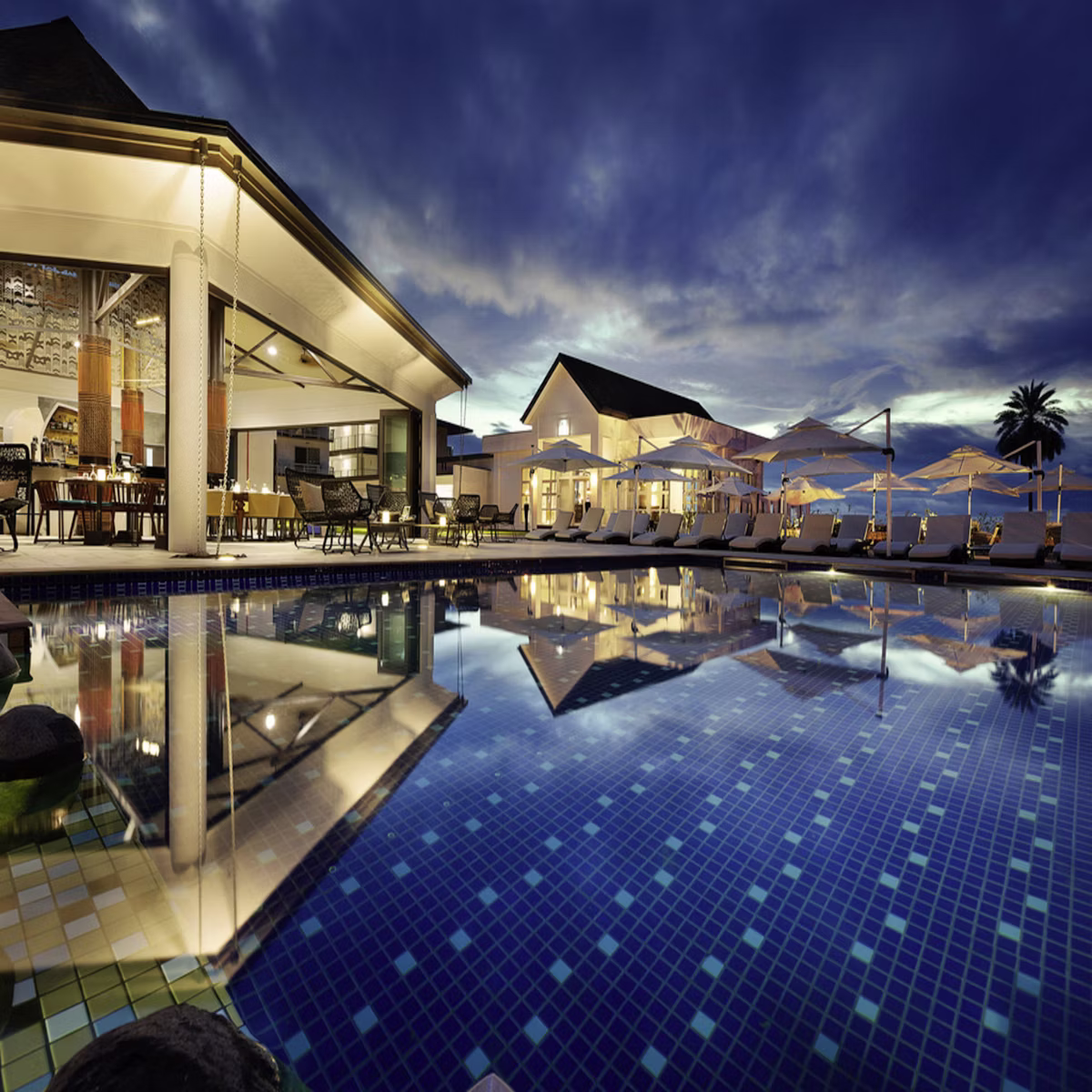 Infinity pool merging with the ocean at sunset